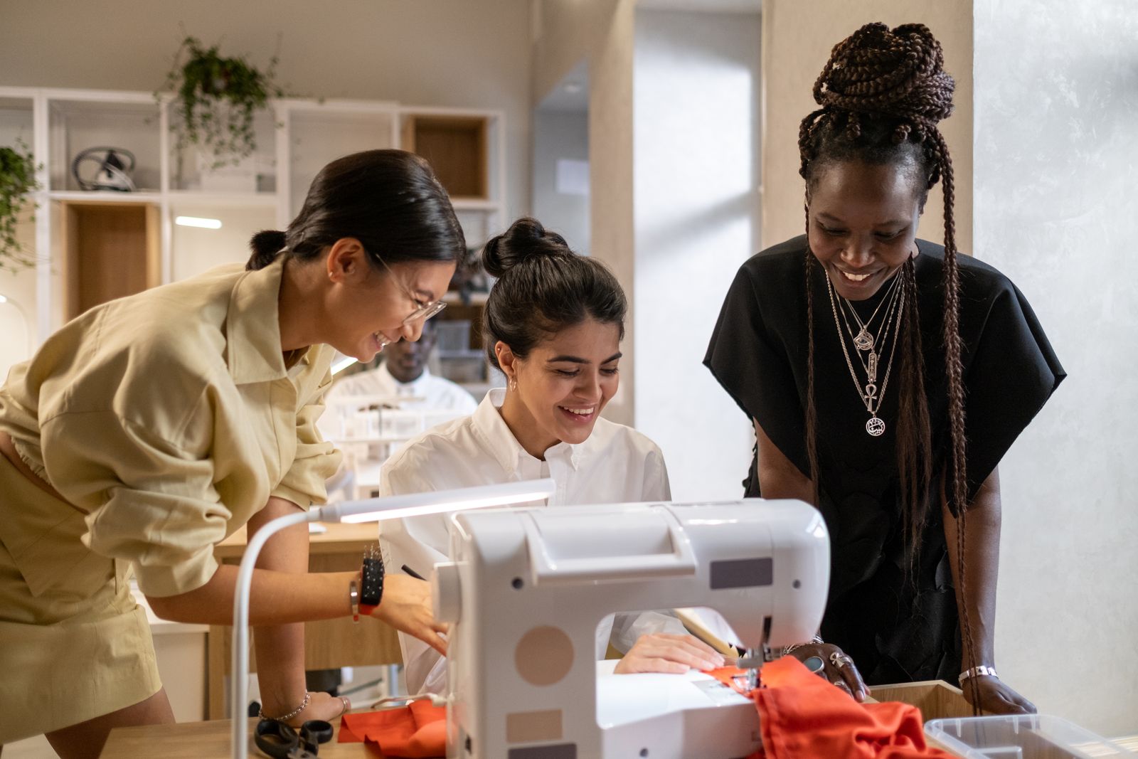 Group of sewists laughing and working together in a sewing studio — I Can Help Sew Flowood class